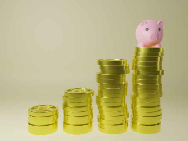 コインが貯まっていくのを表した四列のコインと置かれた豚の人形