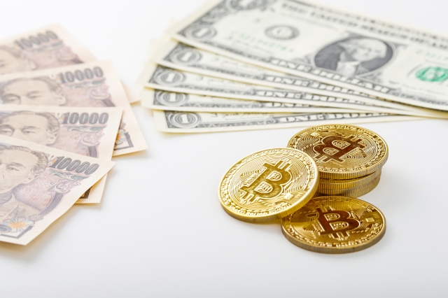 1万円札とドル札、ビットコインが並んで置かれている写真
