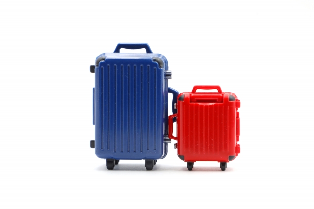 大きい青のスーツケースと小さい赤のスーツケースが置いてある