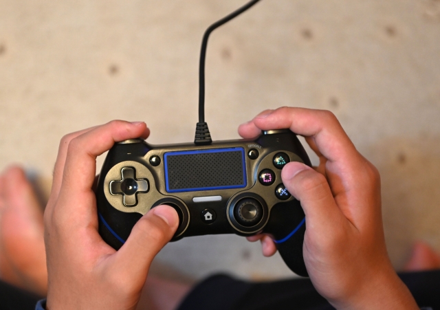 ゲームのコントローラーを両手で持っている写真