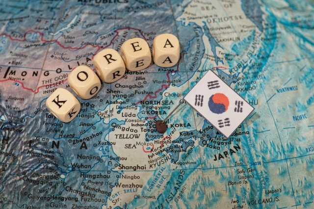 世界地図の上にKOREAと書かれたキューブと韓国国旗が置かれている