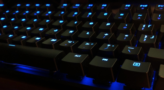 青いライトがついた黒いゲーミングキーボードのアップショット