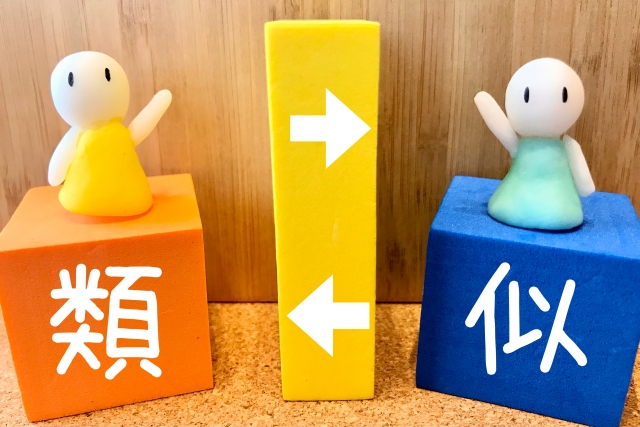オレンジと青のブロックに一字ずつ書かれた「類似」とブロック上に置かれた人形