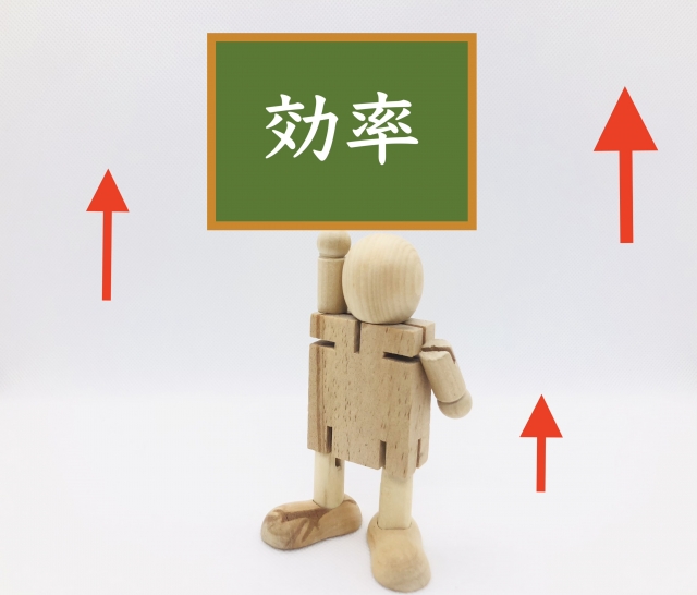 効率と書いたボードを片手で掲げる木製の人形と赤い上向き矢印