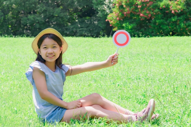 マルが書かれたカードを持つ子供