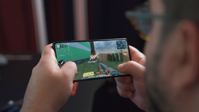 男性がスマホでゲームをしている