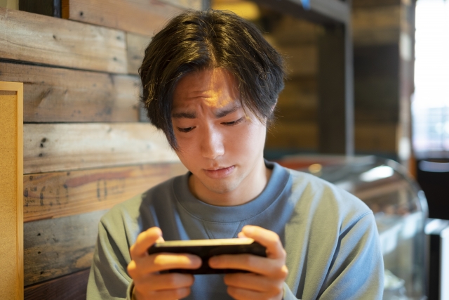 男性がスマホでつまらない