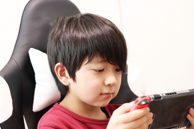 ゲーミングチェアに座ってゲームをする少年