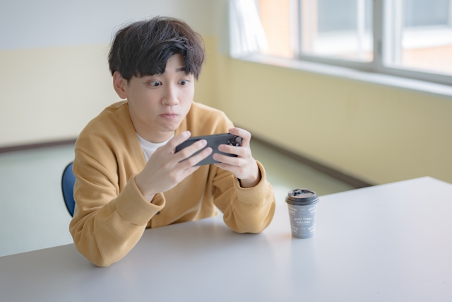 スマホゲームに夢中な男性