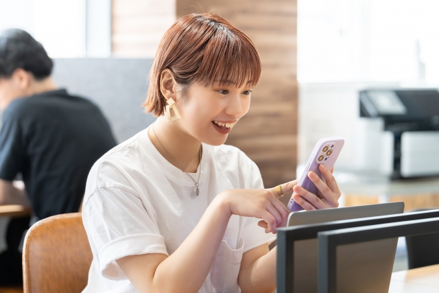 スマホを見て笑顔の女性