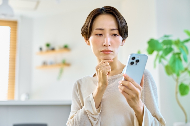 スマホを見て不満そうな女性