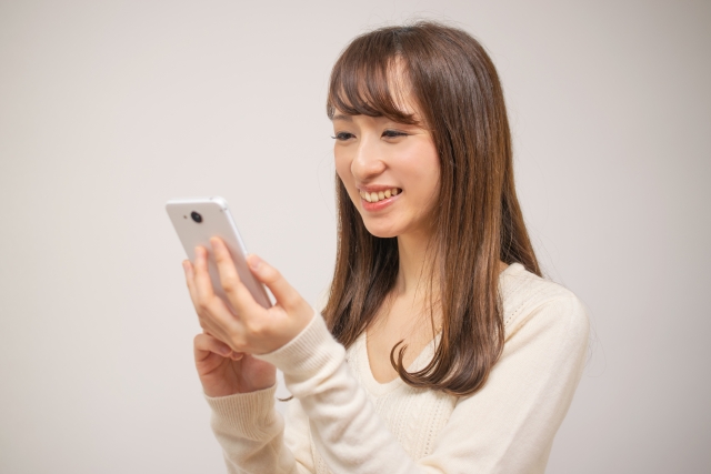 スマホを見て笑顔の女性