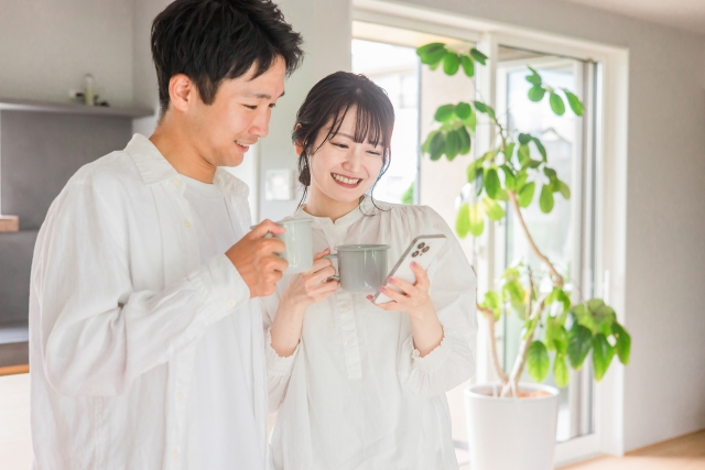 男性と女性がスマホを見て笑いあっている