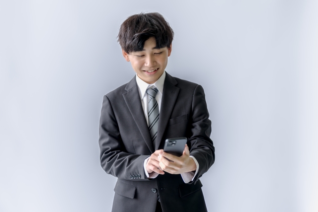 スマホを持って笑っている男性