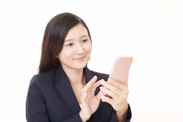 スマホ片手に微笑む女性